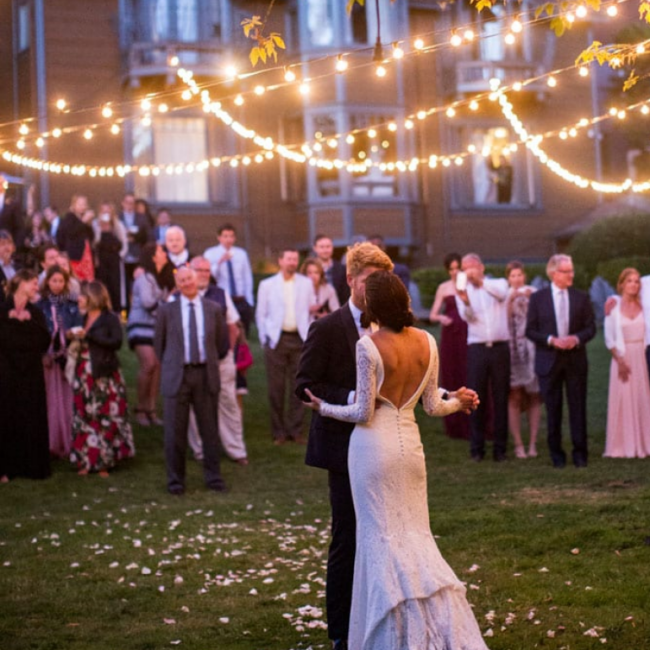 Couple dancing at outdoor wedding with onlookers at Olema House