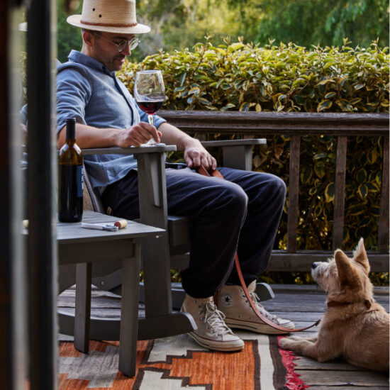 A MAN DRINKING WINE WITH A DOG AT OLEMA HOUSE